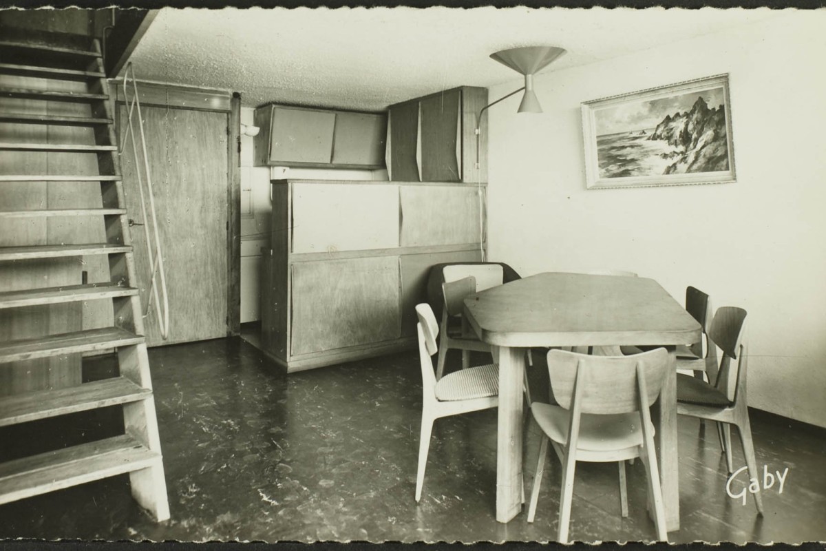 La Maison Radieuse ; vue intérieure d'une salle de séjour et d'un coin cuisine avec le mobilier d'origine